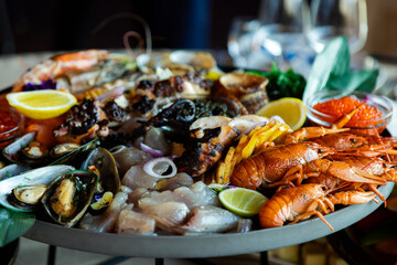 Closeup footage of assortment of seafood with sauces in a round tray, against blur background
