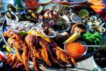 Closeup footage of assortment of seafood with sauces in a round tray, against blur background