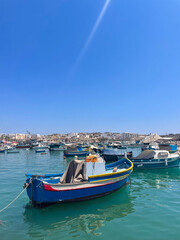Obraz premium Traditional sailing boats in Marsaxlokk town pier in Malta Island, Mediterranean Sea