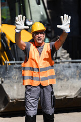 Construction worker signaling during project in bright safety gear on a sunny day at a construction site