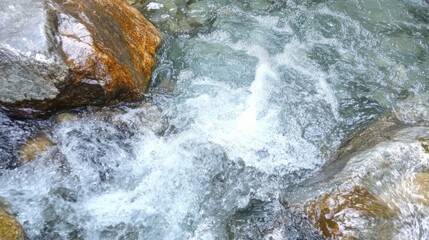 Crystal clear mountain river with flowing water and stones, refreshing natural landscape.