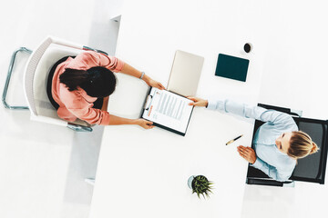 Two young business women in meeting at office table for job application and business agreement....