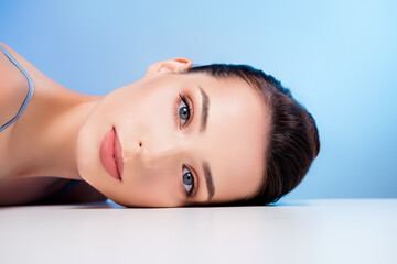 Obraz premium Photo of stunning lovely girl lying white desk looking having shiny skin face isolated blue color background