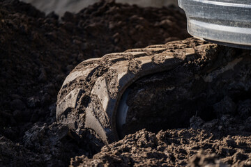 Standard rubber track of mini excavator working in deep muddy surface conditions outdoor at October...