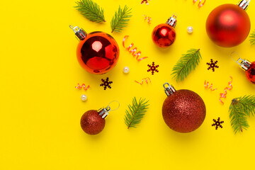 Red christmas balls with decor on color background, top view
