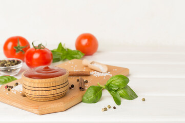 Delicious ketchup with spices and tomatoes on wooden table