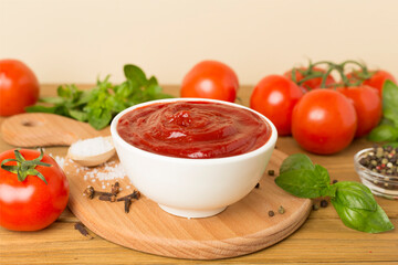 Delicious ketchup with spices and tomatoes on wooden table