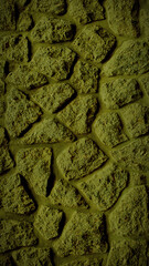 A vertical 4K background featuring a grainy stone wall in dark olive green tones, ideal for rustic backdrops, banners, and textured wallpaper designs