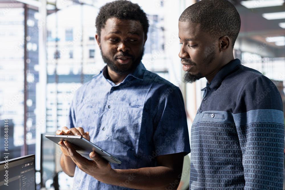 Poster coworkers looking at tablet, managing cloud computing resources and platforms to train machine learn