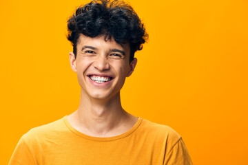 cheerful young man smiling, bright orange background, casual attire, positive energy, happiness...