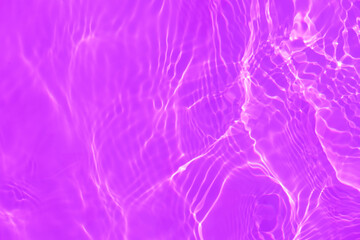 Purple water bubbles on the surface ripples. Defocus blurred transparent pink colored clear calm water surface texture with splash and bubbles. Water waves with shining pattern texture background