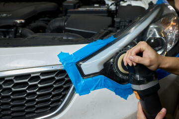 Person using a machine to polish automotive lighting on a car headlight