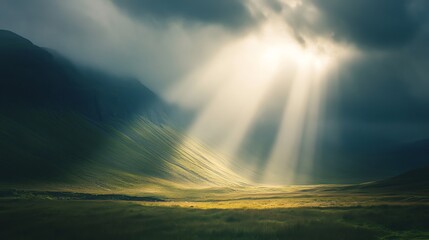 Sunbeams break through the clouds, illuminating a valley.
