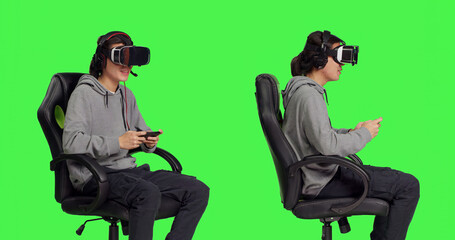 Gamer uses virtual reality for gameplay with mobile phone app, sitting on gaming chair in isolated greenscreen studio. Asian person playing multiplayer action video games with vr.