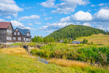 Jizerka village nestles at the foot of Bukovec Mountain, surrounded by lush forests and vibrant meadows