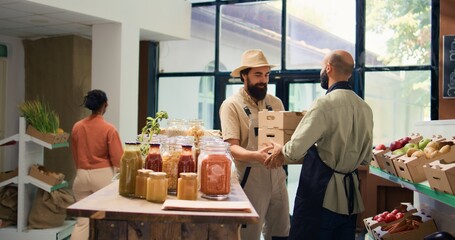 Farmer supplies zero waste eco shop with freshly harvested fruits and veggies, bringing crates...