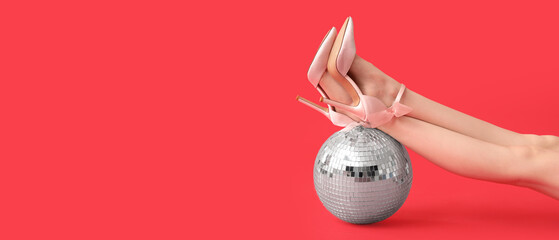 Female legs in high heeled shoes and disco ball on red background with space for text
