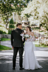  Bride and groom sharing a loving gaze in an outdoor setting, with string lights in the background....