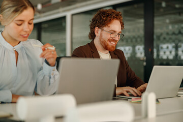 Two dedicated professionals are engaged in a highly productive and innovative collaboration at a sleek office workspace