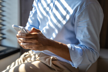 Unrecognizable businessman holding smartphone using digital technology application