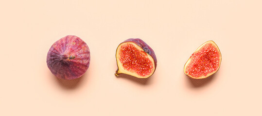 Fresh juicy cut figs on pale pink background