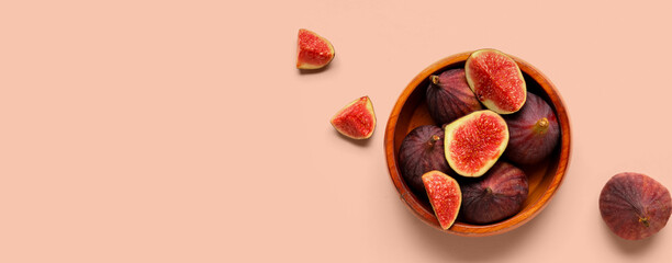 Bowl with fresh juicy cut figs on pale pink background