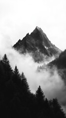 Obraz premium Mountain peak shrouded in mist and clouds, monochrome view. Tranquil nature and solitude concept