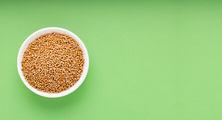 Yellow mustard seeds in bowl - Sinapis alba