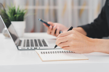 Male hand taking notes on the notepad. businessman working at work table, checklist writing...