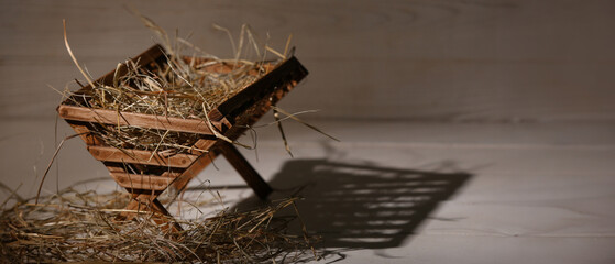 Manger with hay on light wooden background. Concept of Christmas story