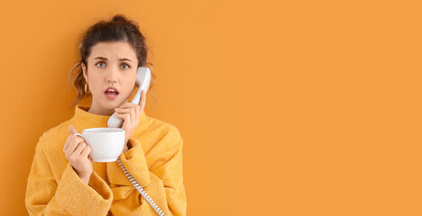 Beautiful young woman with cup of tea talking by phone against color background