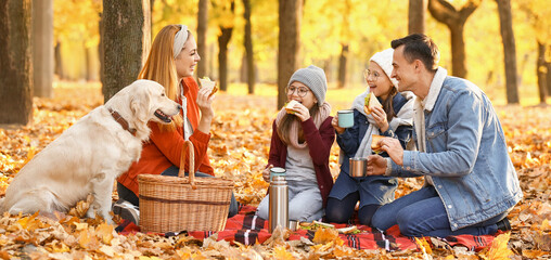 Happy family having picnic in autumn park