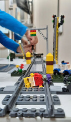Fototapeta premium A boy is playing with a railroad and a construction set. toy railway