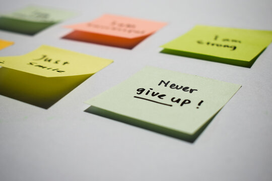 Never give up on sticky notes. Motivational words for personal development, inspirational handwriting. Isolated background