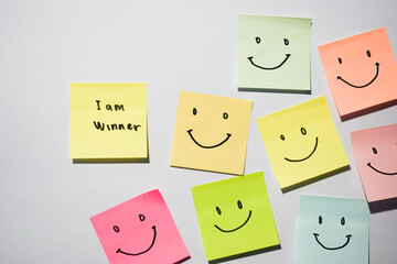 I am winner and smile emoticon on sticky notes. Motivational words for personal development,...