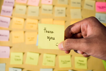 Hand hold sticky notes with words Thank you. Motivational words for personal development,...