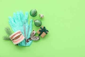 Dentist's tools with Christmas decor and gift on green background