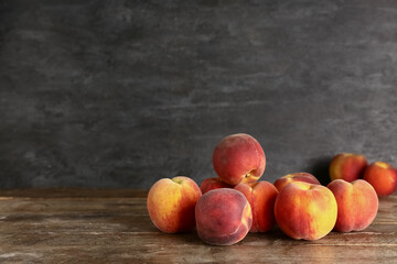 Many sweet peaches on wooden table