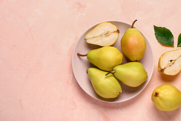 Plate with fresh pears on pink background