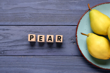 Word PEAR and plate with fresh fruits on blue wooden background
