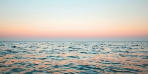 Obraz premium A peaceful sky over a calm ocean at sunset, with soft pastel colors and gentle waves below