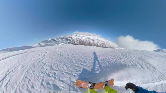 SELFIE, FPV: Adventurous snowboarder enjoys perfect conditions, riding untouched powder snow in high mountains on sunny day. Beauty and thrill of backcountry snowboarding in pristine winter wonderland