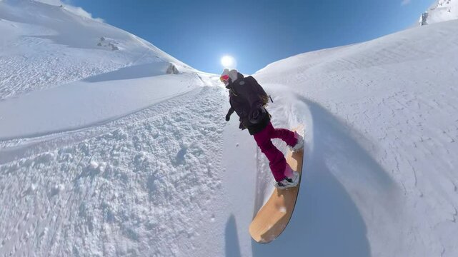 SELFIE, PORTRAIT, LENS FLARE: Snowboarder carving down a pristine mountain slope covered in fresh powder snow on a sunny day. Beauty of snowboarding in untouched backcountry terrain of Albanian Alps.