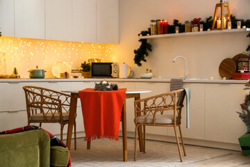 Interior of kitchen with counters, dining table and Christmas lights