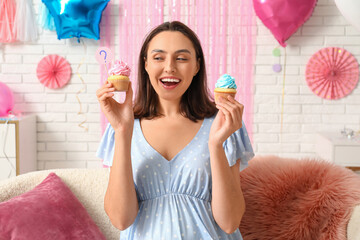 Beautiful pregnant happy woman with delicious cupcakes and question mark at home. Gender reveal...
