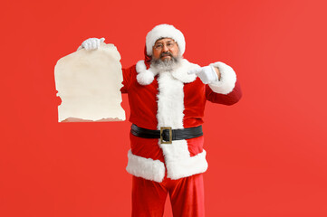 Santa Claus pointing at blank letter on red background