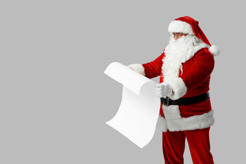 Santa Claus with reading letter on grey background
