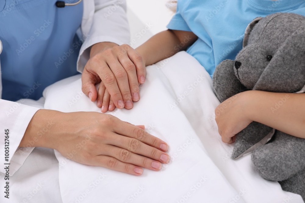 Sticker Doctor examining little girl on bed at hospital, closeup