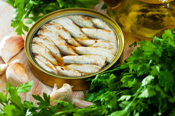 Open tin can with sardines in oil.