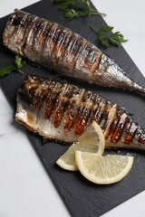 Delicious grilled mackerel, parsley and lemon on white table, top view
